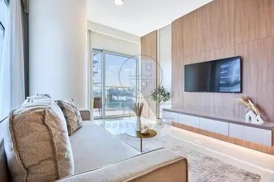 a living room with a couch and a tv at Elegant beachfront living at Emaar Beachfront DXB! in Dubai