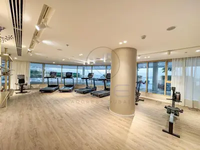 a gym with treadmills and cardio equipment in a building at Elegant beachfront living at Emaar Beachfront DXB! in Dubai