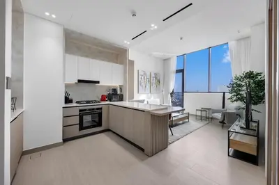 a kitchen with white walls and a large window at Chic 1BR Retreat with Private Pool and Balcony in JVC in Dubai