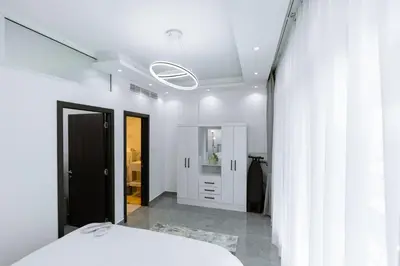 a bedroom with a white bed and a mirror at Dubai Marina - 1BHK Apartment near Dubai Metro in Dubai