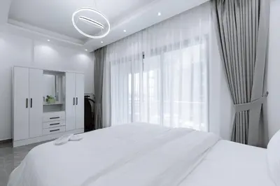 a white bedroom with a large bed and a window at Dubai Marina - 1BHK Apartment near Dubai Metro in Dubai