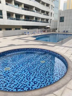 a large pool with blue tiles in front of a building at Dubai Marina - 1BHK Apartment near Dubai Metro in Dubai