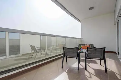 a room with two chairs and a table and a glass wall at Frank Porter - Hera Tower in Dubai