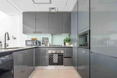 a kitchen with gray cabinets and a stove at Frank Porter - Sunrise Legend in Dubai