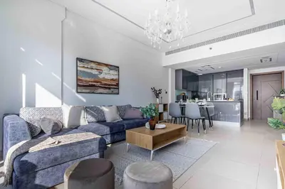 a living room with a blue couch and a table at Frank Porter - Sunrise Legend in Dubai