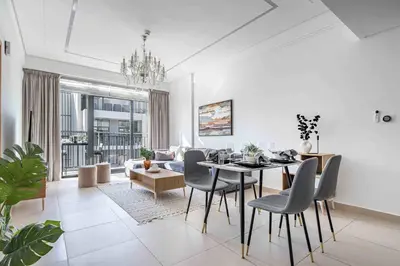 a dining room and living room with a table and chairs at Frank Porter - Sunrise Legend in Dubai