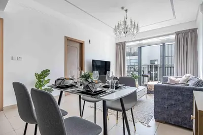 a dining room with a table and chairs in a living room at Frank Porter - Sunrise Legend in Dubai