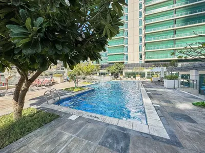 a swimming pool in front of a tall building at Frank Porter - Al Majara, Dubai Marina in Dubai