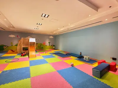 a room with a play room with a large colorful floor at Frank Porter - Al Majara, Dubai Marina in Dubai