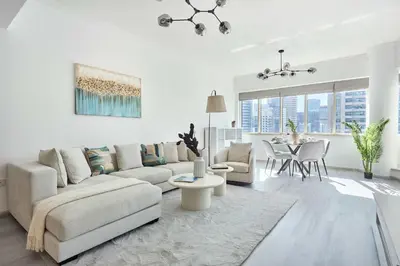 a white living room with a couch and a table at Frank Porter - Al Majara, Dubai Marina in Dubai