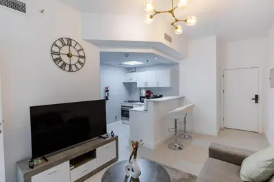 a living room with a flat screen tv on a wall at Dubai Marina - 1BHK Cozy Vacation Homes near Metro in Dubai