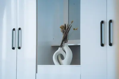 a white cabinet with a vase in it at Dubai Marina - 1BHK Cozy Vacation Homes near Metro in Dubai