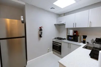 a kitchen with white cabinets and a stainless steel refrigerator at Dubai Marina - 1BHK Cozy Vacation Homes near Metro in Dubai