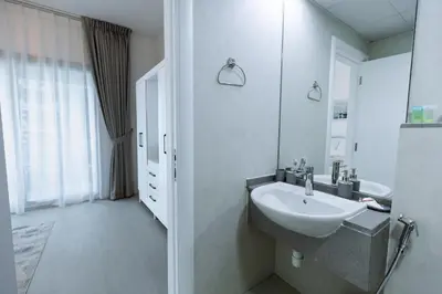 a white bathroom with a sink and a mirror at Dubai Marina - 1BHK Cozy Vacation Homes near Metro in Dubai