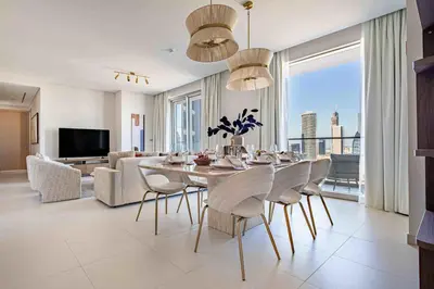 a dining room with a table and chairs and a couch at Frank Porter - Vida Dubai Mall, Downtown in Dubai