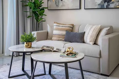 a living room with a couch and two tables at Frank Porter - Skyz By Danube in Dubai