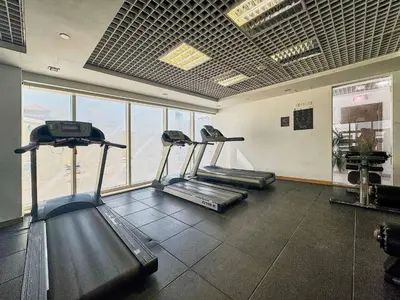 a gym with two treadmills in a room with windows at Frank Porter - Goldcrest Executive in Dubai