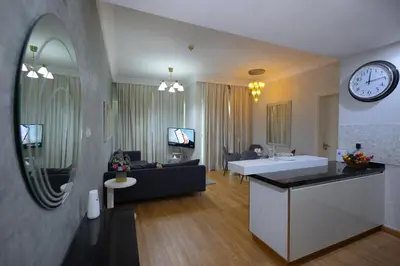 a living room with a couch and a clock on the wall at Damac Downtown 1 BHK apartment with Burj Khalifa view in Dubai
