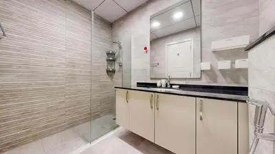 a bathroom with a sink and a glass shower at Luxury 2br Penthouse Spacious in Dubai