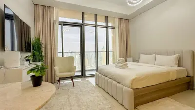 a bedroom with a bed and a chair and a window at High floor studio with stunning views in Aykon City in Dubai