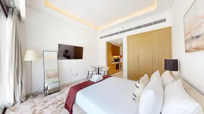 a bedroom with a white bed and a television at Luxurious Chic Comfort Studio in Dubai