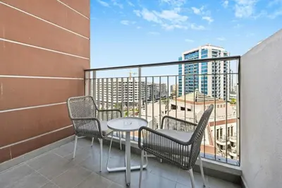 a balcony with a table and chairs and a view of a city at Bloomfields Stunning STU, Elz By Danube, Dubai in Dubai