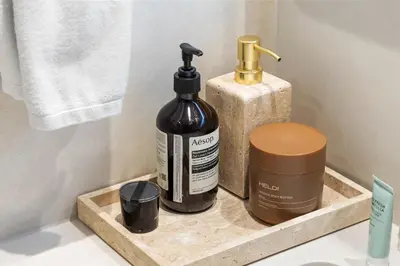 a bathroom shelf with a bottle of soap and a soap dispenser at Serene Creek Harbour Escape with Burj Khalifa View in Dubai