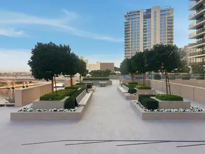 a walkway with trees and bushes on a building at Serene Creek Harbour Escape with Burj Khalifa View in Dubai