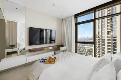 a bedroom with a white bed and a large window at Serene Creek Harbour Escape with Burj Khalifa View in Dubai