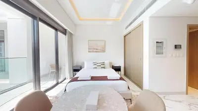 a bedroom with two beds and a table and chairs at Modern Furnished Studio Azizi Riviera in Dubai