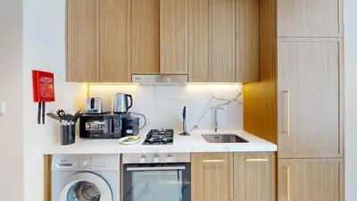 a kitchen with a sink and a washing machine at Modern Furnished Studio Azizi Riviera in Dubai