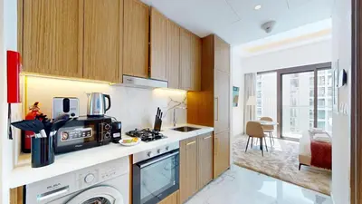 a kitchen with a sink and a stove top oven at Modern Furnished Studio Azizi Riviera in Dubai