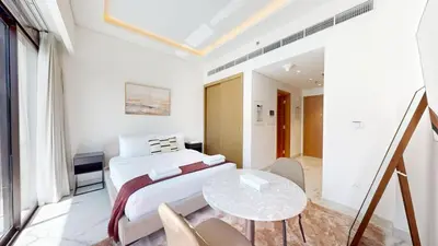 a bedroom with a bed and a table at Modern Furnished Studio Azizi Riviera in Dubai