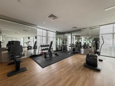 a gym with several treadmills and chairs and mirrors at Settler Homes - Premium Matrix Tower with Hot Tub in Dubai