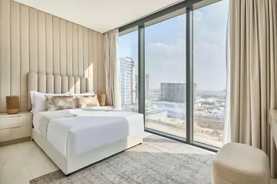 a bedroom with a white bed and a large window at Frank Porter - The Crest Tower, Sobha Hartland in Dubai