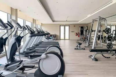 a gym with several treadmills and machines in a room at Frank Porter - The Crest Tower, Sobha Hartland in Dubai