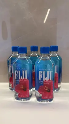 four bottles of fliji water sitting on a shelf at Lux 2 Bedroom Cozy Family Getaway Home in Dubai