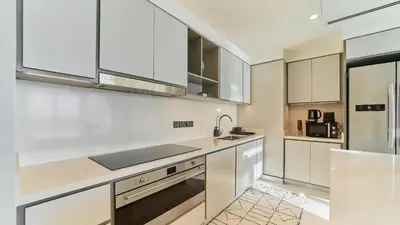 a kitchen with white cabinets and stainless steel appliances at Prime 3BR Maid Sunrise Bay Ain Dubai Palm View in Dubai
