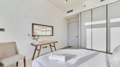 a bedroom with a bed and a chair and a mirror at Prime 3BR Maid Sunrise Bay Ain Dubai Palm View in Dubai