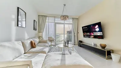 a living room with a couch and a tv at Prime 3BR Maid Sunrise Bay Ain Dubai Palm View in Dubai