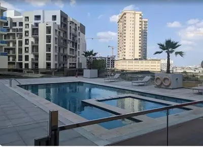 a large swimming pool in a city with tall buildings at Luxurious full renovated apartment in Dubai