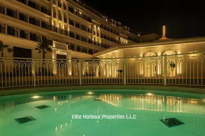 a swimming pool in front of a building at night at Luxury Apartment in Vincitore Benessere, Dubai in Dubai