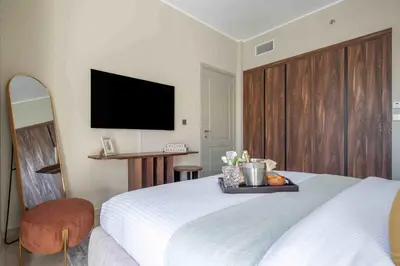 a bedroom with a bed and a tv on the wall at Frank Porter - Avenue Residence in Dubai