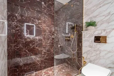 a bathroom with a marble shower with a toilet at Frank Porter - Avenue Residence in Dubai