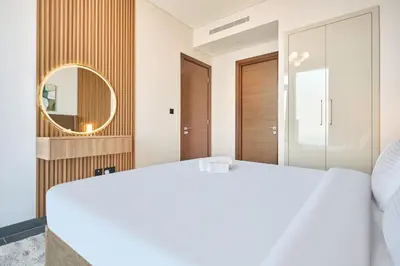 a bedroom with a white bed and a mirror at STAY BY LATINEM Luxury 1BR Holiday Home CB 3814 Near Burj Khalifa in Dubai