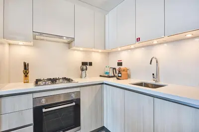 a kitchen with white cabinets and a sink at STAY BY LATINEM Luxury 1BR Holiday Home CB 3814 Near Burj Khalifa in Dubai
