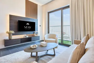 a living room with a couch and a tv and a table at STAY BY LATINEM Luxury 1BR Holiday Home CB 3814 Near Burj Khalifa in Dubai