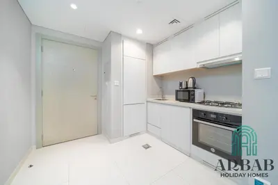 a kitchen with white cabinets and a stove at Arbab Homes Luxury 1BR - Canal View - Damac Zada Tower in Dubai