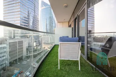 a room with a chair on a balcony with tall buildings at Arbab Homes Luxury 1BR - Canal View - Damac Zada Tower in Dubai