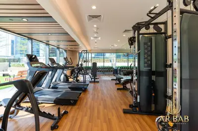 a gym with treadmills and elliptical machines at Arbab Homes Luxury 1BR - Canal View - Damac Zada Tower in Dubai
